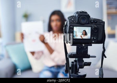 Aider les autres à apprendre comment appliquer le maquillage par vlogging. Photo courte d'une jeune femme attrayante travaillant à la maison. Banque D'Images