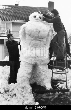 Deux jeunes hommes construisent un bonhomme de neige géant, au pays de Galles, le 22nd février 1978. Banque D'Images