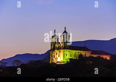 Vue nocturne de l'église historique du 18th siècle et des collines de la ville d'Ouro Preto Banque D'Images