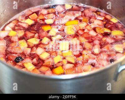 Le vin chaud avec beaucoup de fruits est cuit dans un panoramique Banque D'Images