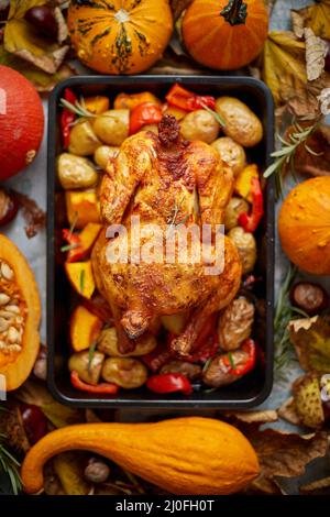 Poulet entier rôti ou dinde avec citrouilles, poivre et pommes de terre. Avec mini-citrouilles colorées Banque D'Images