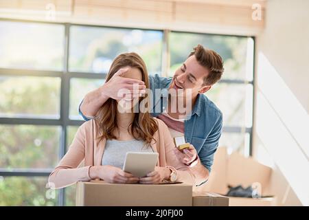 La grande surprise. Photo rognée d'un jeune homme surprend sa petite amie en proposant tout en déménagent. Banque D'Images