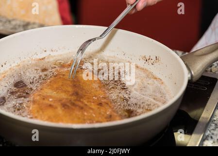 L'escalope de veau est frite dans une poêle - Wiener Schnitzel Banque D'Images