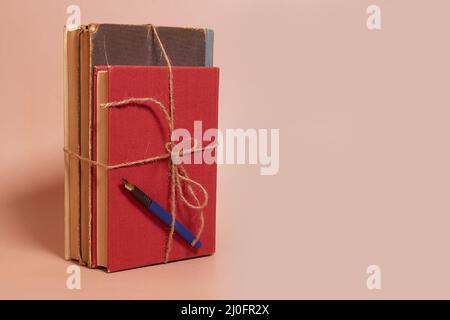 Une pile de vieux livres battus attaché avec une corde de jute et un stylo de fontaine Banque D'Images