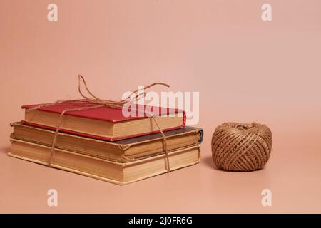 Une pile de vieux livres battus attaché avec la corde de jute, une bobine de corde de jute Banque D'Images