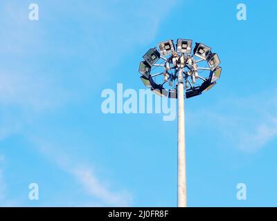 Lampadaire haut avec de nombreux spots dans un cercle contre le ciel bleu Banque D'Images