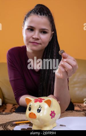 Jusqu'à la fin d'un long mois, les adolescents ont été laissés avec les dernières centimes d'économies. La fille tient un dix dans son doigt Banque D'Images