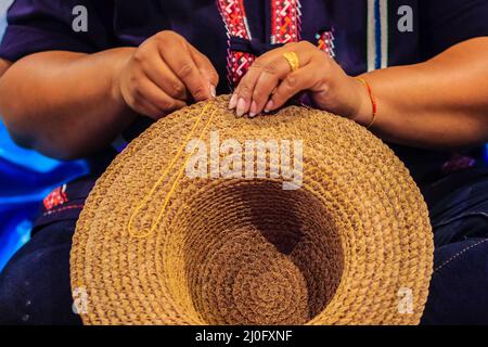 Femme ouvrier d'artisanat couture de la banane traditionnelle séchée feuilles chapeau à un artisanat villages.chapeau fait à partir de feuilles de banane sèches, Banque D'Images