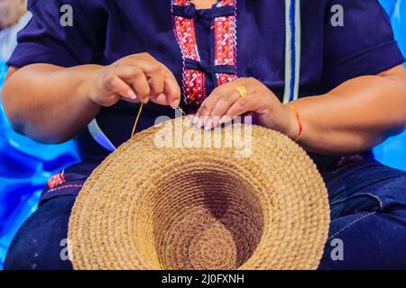 Femme ouvrier d'artisanat couture de la banane traditionnelle séchée feuilles chapeau à un artisanat villages.chapeau fait à partir de feuilles de banane sèches, Banque D'Images