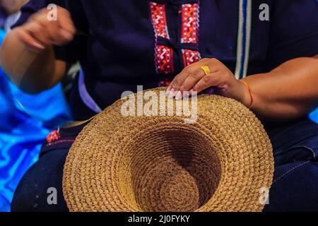 Femme ouvrier d'artisanat couture de la banane traditionnelle séchée feuilles chapeau à un artisanat villages.chapeau fait à partir de feuilles de banane sèches, Banque D'Images