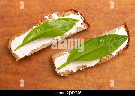 Sandwichs à partir de tranches de pain avec mayonnaise et feuilles de ramson, vue de dessus en gros plan Banque D'Images