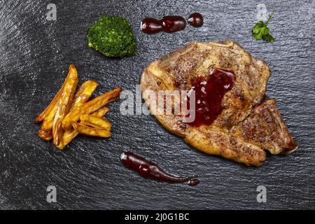 Côtelettes de veau et frites sur ardoise Banque D'Images