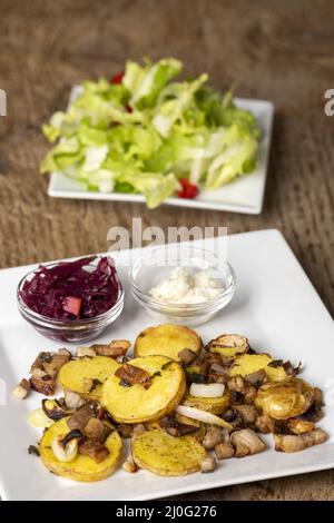 Gröstl bavarois avec salade sur bois Banque D'Images