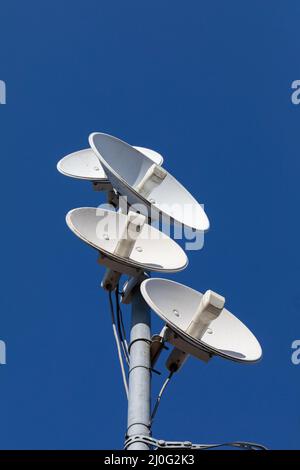 Plusieurs antennes de télécommunications d'un réseau cellulaire et Internet sans fil contre un ciel bleu. Réception et numérisation de mul Banque D'Images