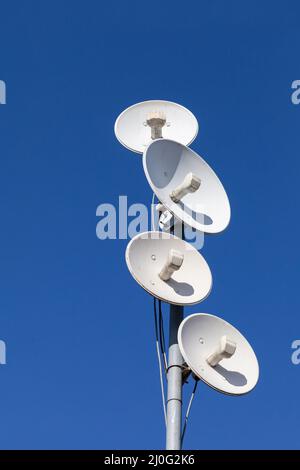 Plusieurs antennes de télécommunications d'un réseau cellulaire et Internet sans fil contre un ciel bleu. Réception et numérisation de mul Banque D'Images