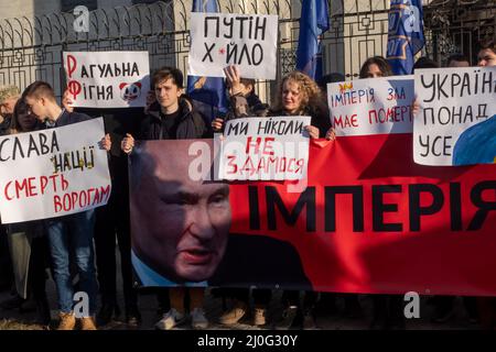 KIEV, UKRAINE 22 FÉVRIER. Les manifestants ukrainiens arborent une bannière et des signes exprimant leur opinion lors d'un rassemblement appelé « l'Empire doit mourir » devant l'ambassade de Russie après que Poutine ait reconnu deux régions ukrainiennes le 22 février 2022 à Kiev, en Ukraine. Le Parlement russe a approuvé des traités avec deux régions sécessionnistes de l'est de l'Ukraine, ouvrant la voie à un déploiement immédiat de troupes russes. Banque D'Images