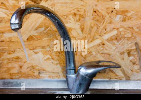 Icicle sur le robinet d'eau glacée en gros plan à l'intérieur. Mise au point sélective Banque D'Images