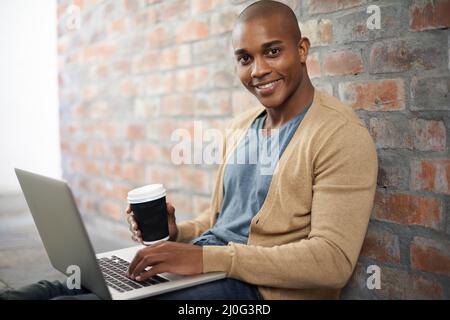 Il est facile à travailler lorsque vous vous sentez à l'aise. Photo courte d'un beau jeune homme travaillant sur un ordinateur portable. Banque D'Images