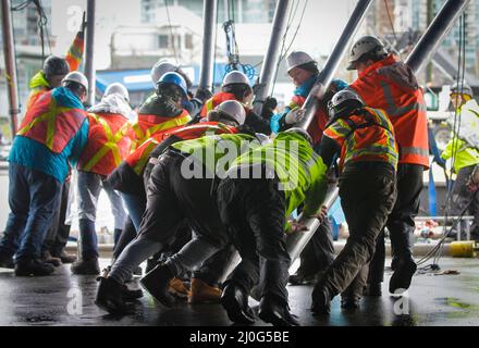 Vancouver, Canada. 18th mars 2022. Les travailleurs poussent les bâtons de soutien pour élever le haut de la tête à sa position finale pour le spectacle à venir du Cirque du Soleil, Alegria, à Concord Pacific place, à Vancouver, en Colombie-Britannique, au Canada, le 18 mars 2022. Plus de 60 travailleurs ont poussé plus de 100 bâtons de soutien pour élever la toile dans sa position finale afin de mettre en place le célèbre Big Top, où aura lieu la scène principale du Cirque du Soleil. Credit: Liang Sen/Xinhua/Alay Live News Banque D'Images