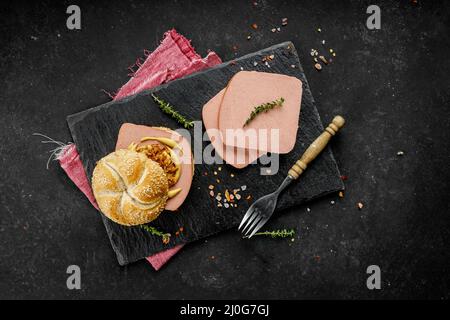 Composition de plats composés de délicieux hot dogs et sandwichs avec différentes garnitures sur fond sombre Banque D'Images