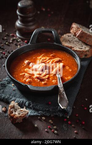 Soupe savoureuse et chaude à la tripe, à base de légumes et de bœuf. Soupe épicée et aromatique à la tripe assaisonnée de poivre et servie avec du pain. Banque D'Images