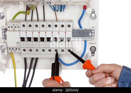 Un électricien teste un circuit électrique Banque D'Images