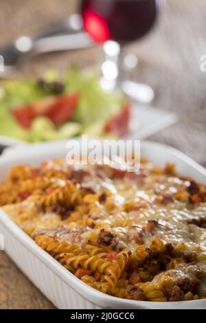 Pâtes au gratin avec salade sur bois Banque D'Images