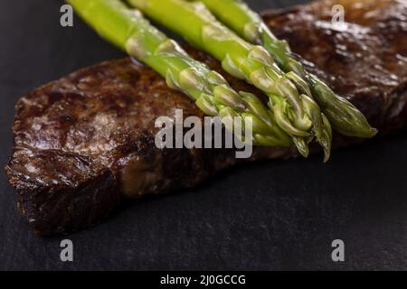 Asperges vertes sur un steak Banque D'Images