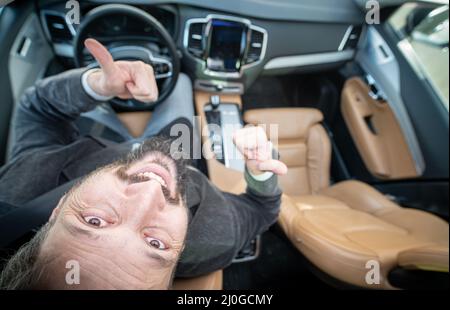 Grand angle d'un conducteur mâle dans une voiture de luxe Banque D'Images