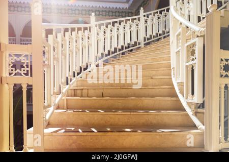 Un bel escalier avec des rampes blanches monte. Marches en gros plan au soleil Banque D'Images