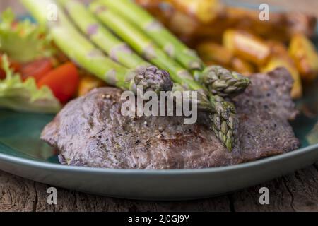 Asperges sur le steak grillé et frites Banque D'Images