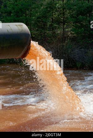 Les eaux usées sont déversées dans la rivière, format portrait Banque D'Images