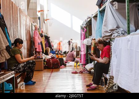 Uzhhorod, Ukraine. 19th mars 2022. Les femmes parcourent leur téléphone dans un gymnase d'une institution universitaire qu'elles partagent avec près de 300 personnes déplacées à l'intérieur du pays qui ont fui l'invasion russe, Uzhhorod, région de Zakarpattia, Ukraine occidentale, le 18 mars, 2022. Photo de Serhii Hudak/Ukrinform/ABACAPRESS. Credit: Abaca Press/Alay Live News Banque D'Images