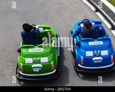 Russie, Sotchi 16.04.2021. Deux petits garçons se trouvent dans des voitures miniatures sur la route de la piste de karting pour enfants. Banque D'Images