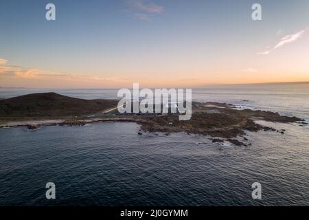 Vue imprenable sur un paysage aérien de drone d'une ferme de pêche en mer sur terre au coucher du soleil à Galiza, Espagne Banque D'Images