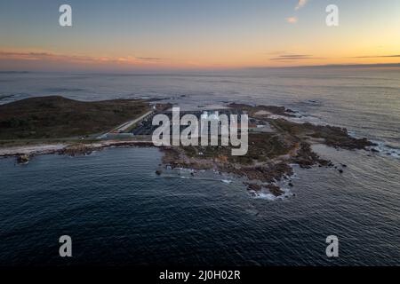 Vue imprenable sur un paysage aérien de drone d'une ferme de pêche en mer sur terre au coucher du soleil à Galiza, Espagne Banque D'Images