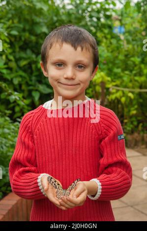 Boy Holding Butterfly, Wye Valley Butterfly Zoo, Symonds Yat, Angleterre, Royaume-Uni Banque D'Images