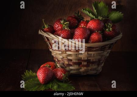 Baies de fraises mûres sur fond de bois sombre dans un style rustique Banque D'Images