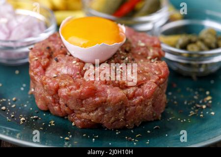 Tartre au steak avec œuf ouvert sur bois Banque D'Images