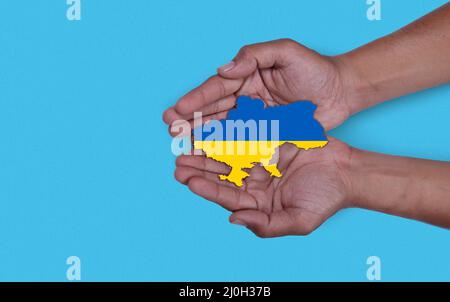 Carte avec imprimer le drapeau national de l'ukraine dans les mains des hommes. Pose à plat. Copier l'espace. Banque D'Images