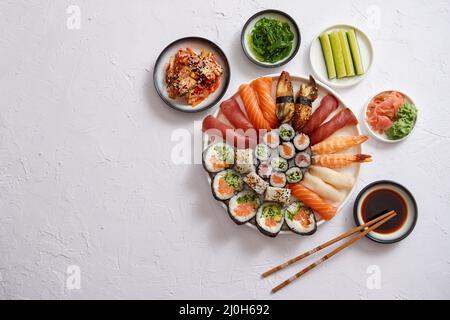Différents rouleaux de sushi placé sur la plaque ronde en céramique Banque D'Images