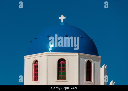 Église grecque blanche avec dôme bleu à Santorin. Banque D'Images