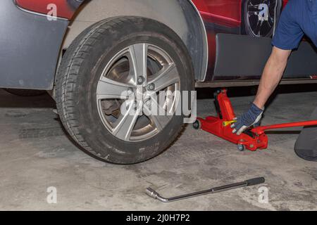 Vue rapprochée d'un homme qui change de pneus d'hiver pour l'été. Concept de transport. Suède. Banque D'Images