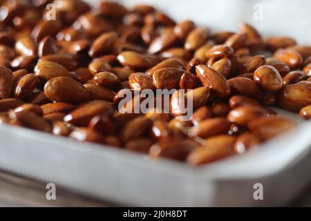 Amandes confites. Amandes grillées enrobées de sirop de caramel. À l'intérieur de la plaque de cuisson Banque D'Images