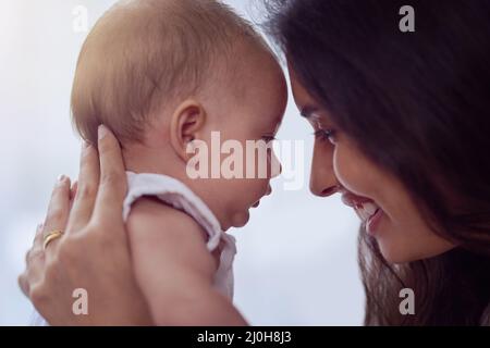 Maman vous aime beaucoup. Photo d'une jeune femme qui se joint à son bébé garçon à la maison. Banque D'Images