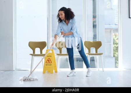 Rien n'est plus unique... voir vos sols étinceler. Photo d'une jeune femme qui se moque de son sol à la maison. Banque D'Images