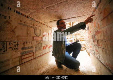 (220319) -- LE CAIRE, le 19 mars 2022 (Xinhua) -- un archéologue présente la peinture murale dans une ancienne tombe découverte sur les sites archéologiques de Saqqara, au sud-ouest du Caire, en Égypte, le 19 mars 2022. Le ministère égyptien du Tourisme et des Antiquités a annoncé jeudi la découverte de cinq tombes anciennes de 4 000 ans dans les sites archéologiques de Saqqara, au sud-ouest du Caire. Les tombes contiennent des découvertes et des objets datant de la fin de l'ancien Royaume s'étendant de 2686 BC à 2181 BC et le début de la première période intermédiaire s'étendant de 2181 BC à 2055 BC. ALLER AVEC 'Egypt dis Banque D'Images