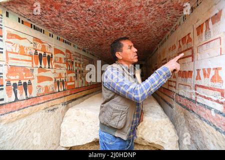 (220319) -- LE CAIRE, le 19 mars 2022 (Xinhua) -- un archéologue présente la peinture murale dans une ancienne tombe découverte sur les sites archéologiques de Saqqara, au sud-ouest du Caire, en Égypte, le 19 mars 2022. Le ministère égyptien du Tourisme et des Antiquités a annoncé jeudi la découverte de cinq tombes anciennes de 4 000 ans dans les sites archéologiques de Saqqara, au sud-ouest du Caire. Les tombes contiennent des découvertes et des objets datant de la fin de l'ancien Royaume s'étendant de 2686 BC à 2181 BC et le début de la première période intermédiaire s'étendant de 2181 BC à 2055 BC. ALLER AVEC 'Egypt dis Banque D'Images