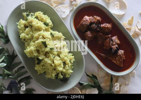 Purée de casava sec ou tapioca sec avec noix de coco râpée, échalotes, piments, curcuma et feuilles de curry. Servi avec du curry de maquereau épicé rouge. Populaire dis Banque D'Images