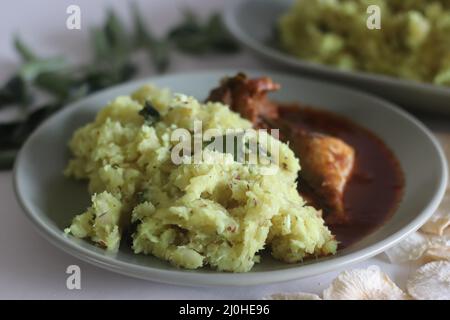 Purée de casava sec ou tapioca sec avec noix de coco râpée, échalotes, piments, curcuma et feuilles de curry. Servi avec du curry de maquereau épicé rouge. Populaire dis Banque D'Images